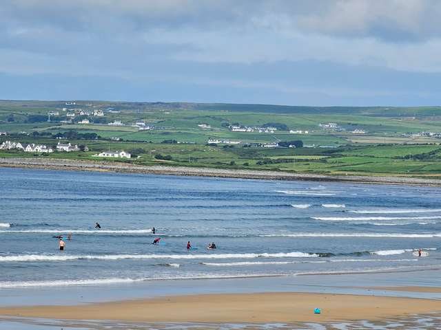 small waves along the beach with a few beginner surfers in the water